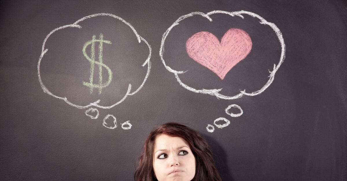 woman standing in front of a chalkboard that has a heart and a dollar sign drawn on it