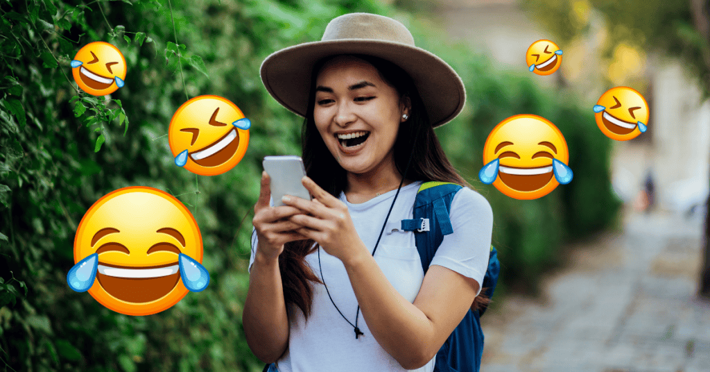 woman laughing at phone with laughing emojis around her