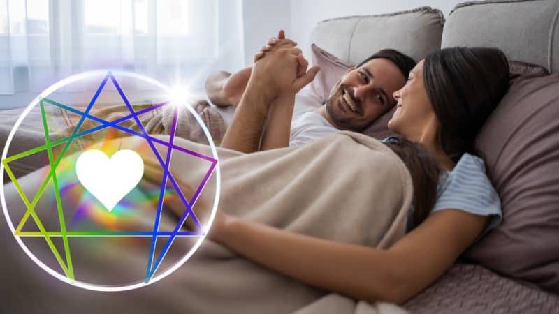 couple holding hands in bed with rainbow enneagram symbol next to them