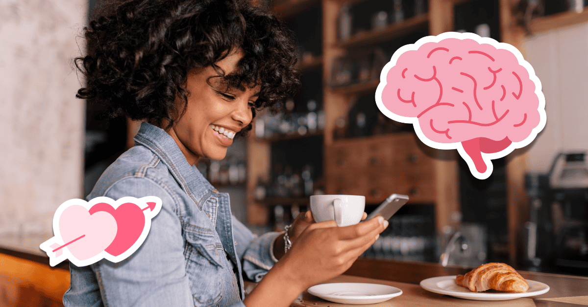 woman looking at phone while drinking coffee at cafe with brain and heart stickers around her