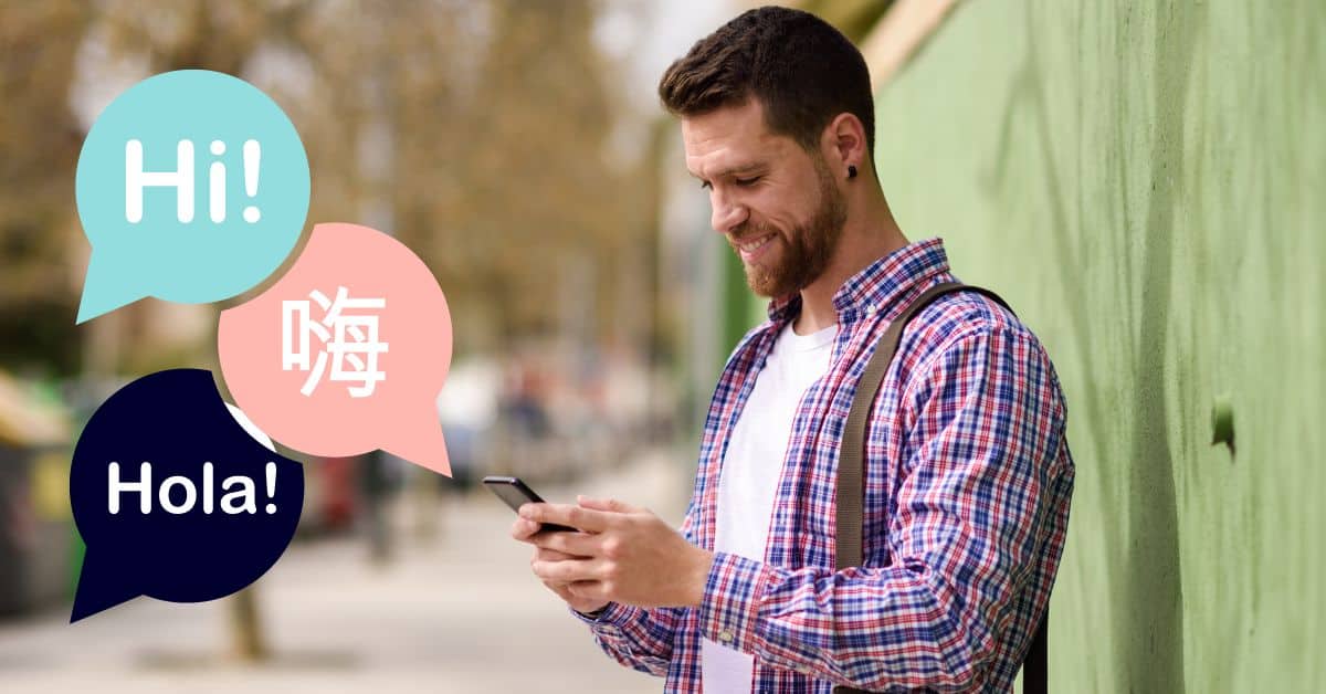 man smiling at phone outside with language graphics