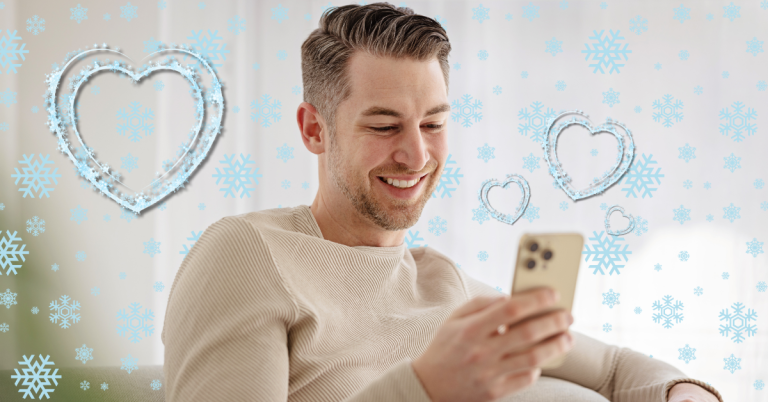 man smiling at phone with snowflakes and hearts around him